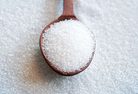 White sugar crystals in a spoon